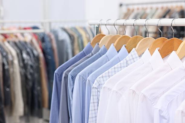 istock Dry-cleaning service. Many different clothes hanging on rack indoors, closeup 2253059803