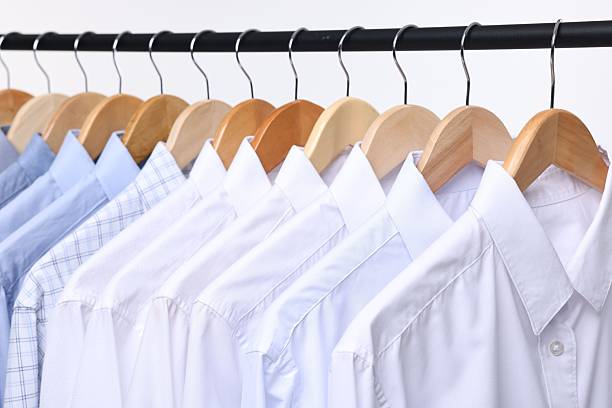 istock Dry-cleaning service. Many different clothes hanging on rack against white background, closeup 2253059873