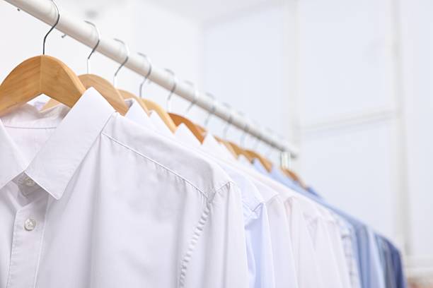 istock Dry-cleaning service. Many different clothes hanging on rack indoors, closeup 2253059883