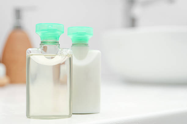 istock Mini bottles of cosmetic products on white table against blurred background. Space for text 2253061746