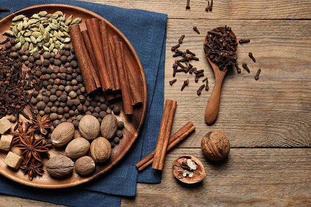istock Spoon with different spices and nuts on wooden table, flat lay 2253063349