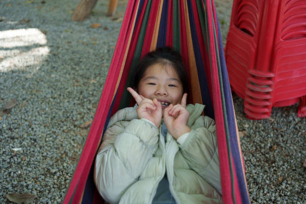 An Asian child lying in a hammock.