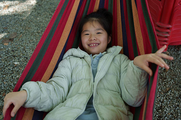 A cute Asian child lying in a hammock.