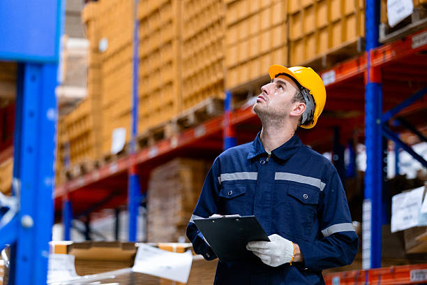 istock Man paper warehouse worker holding tablet checking inspecting quality counting stock on shelves in storage. Large industry in paper product line manufacturing. 2253065827
