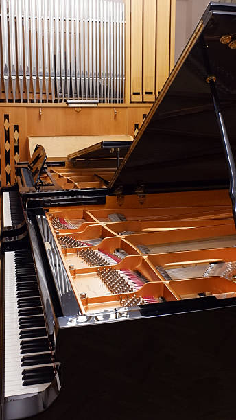 istock Open grand piano showing strings, hammers and keyboard inside a concert hall 2253066379