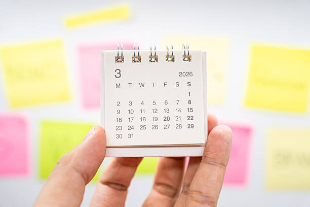 istock Hand holding MARCH 2026 mini calendar with blurred colorful sticky notes for planning concept. project tracking, monthly goal setting, and time management in a creative workspace. 2253066698