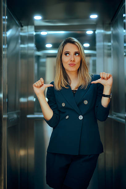 istock Self Important CEO Pointing to herself Entering an Elevator 2253067217