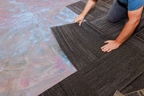 istock Flooring installation process worker placing tiles in modern renovation 2253067811