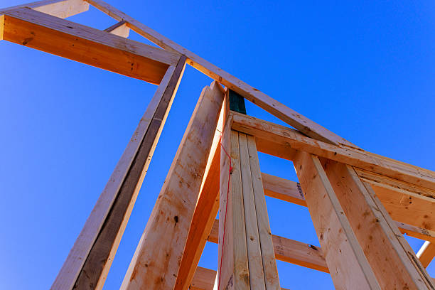 istock Wooden framework of building rises against during construction 2253067827