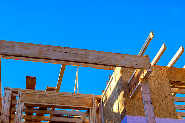 Workers build wooden structure with beams joist installation on roof