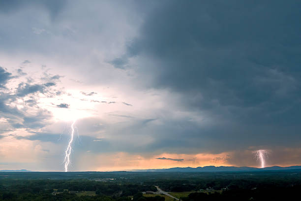 Dramatic lightning strikes illuminate stormy sky over mountains at dusk