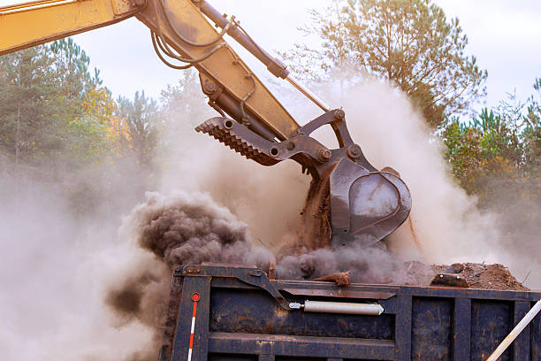 istock Heavy machinery digs dumps earth at construction site in dusty conditions 2253067890