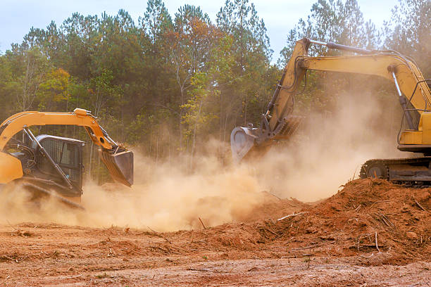 istock Excavators working on land clearing project in autumn landscape with dust clouds rising 2253067898