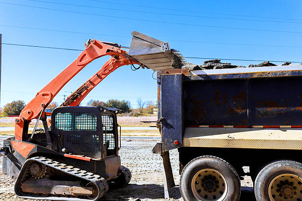istock Bobcat machinery moves soil into dump truck during construction work 2253067923