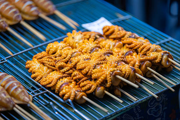 Asian street food market.Seafood (octopus) skewers sales on street food market stand.Phuket Island - Thailand.