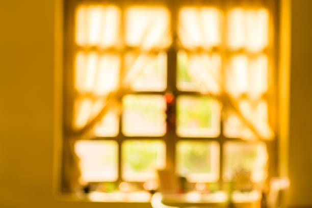 Young woman opening the curtains and enjoying nice view out of window.