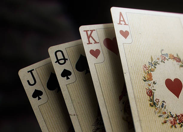 Closeup image of four vintage playing cards featuring jack, queen, king, and ace on a dark background. Ideal for casino themes, poker content, luxury gaming designs - 3D render
