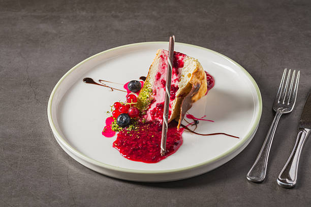 istock Cheesecake slice topped with fresh berries and vibrant sauce 2253077382
