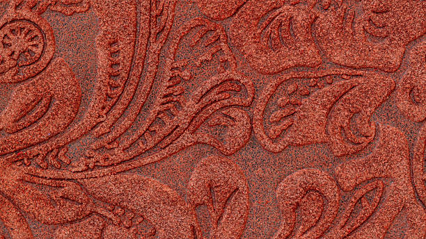 istock Embossed red plaster texture with intricate floral pattern and ornamental swirls. Concept of vintage decoration, floral relief, textured surface 2253078336