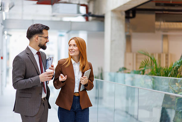 istock Business colleagues walking and talking in office corridor 2253080615