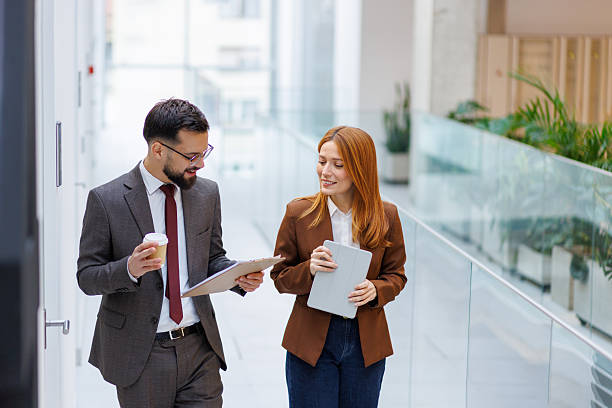 istock Business colleagues walking and discussing work in office hallway 2253080616