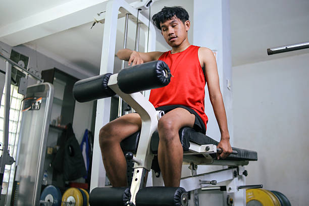 Asian Young Man with Visual Impairment Taking a Break on Gym Equipment During Intense Workout