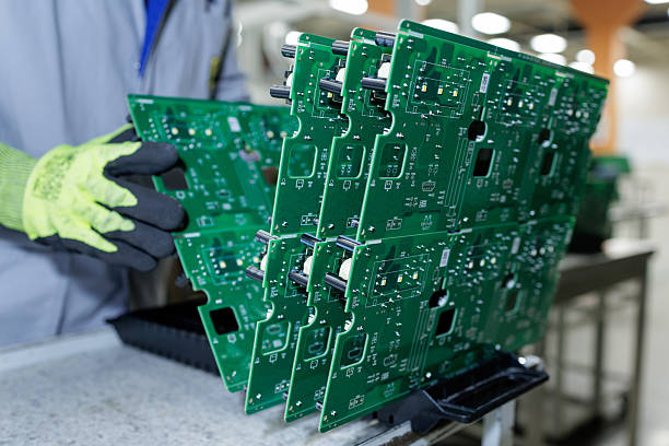 istock Worker handling green printed circuit board panels at electronics factory 2253088489