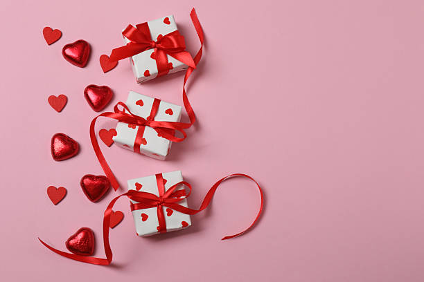 istock Valentine's Day banner with gift boxes surrounded by red hearts on a pink background. Perfect for romantic and festive events. 2253089658