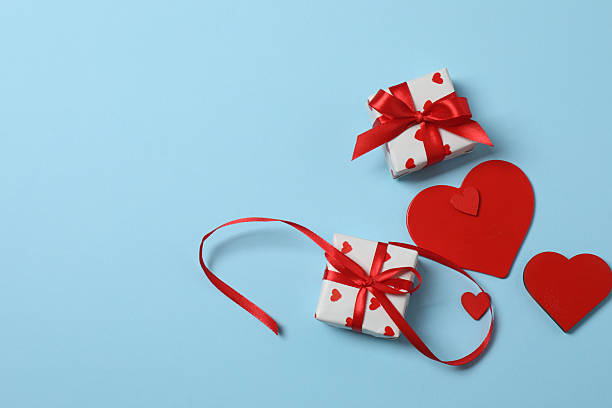 istock Valentine's Day banner with gift boxes surrounded by red hearts on a blue background. Perfect for romantic and festive events. 2253090661