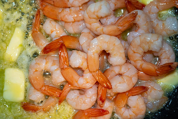 Closeup of fried shrimps in butter on a frying pan.