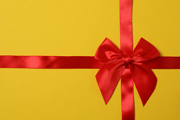Warm golden yellow orange background decorated with red heart shaped bow.