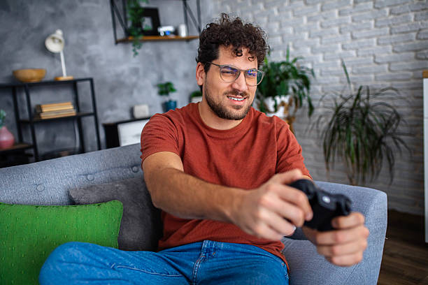 istock Man Playing Video Games with Game Controller at Home 2253096213