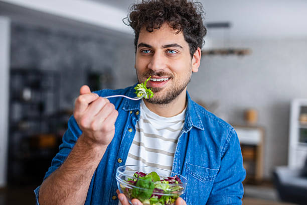 istock Smiling Man Enjoying Healthy Salad at Home 2253097221