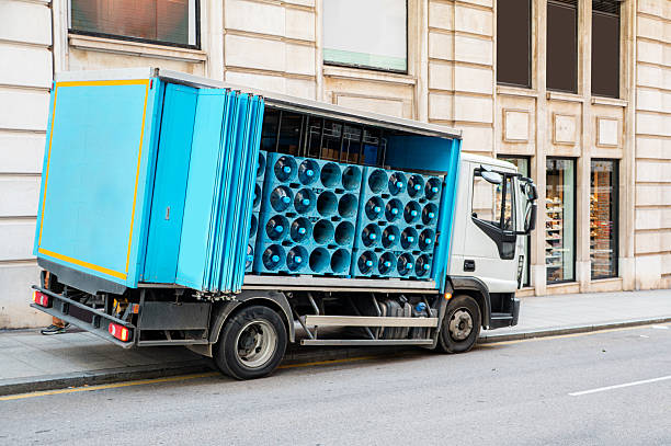Delivery truck carrying large water bottles for commercial distribution. Concept of water supply, logistics, hydration, and distribution services.