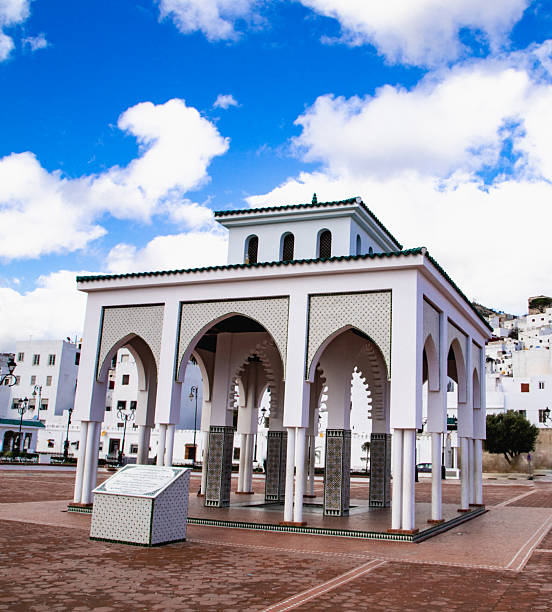 Andalusian-inspired pavilion with elegant arches and geometric patterns, standing on an open square beneath a bright blue sky.