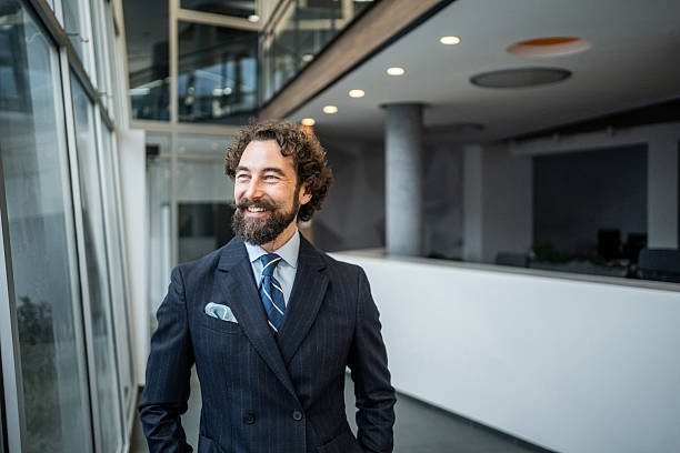 istock Smiling confident businessman standing in modern office building 2253103855