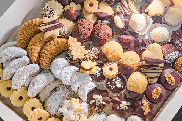 A delightful assortment of Christmas cookies displayed in a festive box, featuring diverse shapes, textures, and colors, ideal for holiday enjoyment