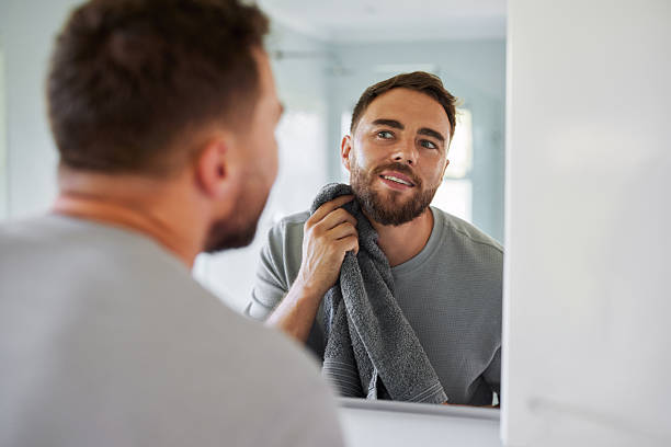 istock Mid adult man looking at mirror during morning routine 2253106734