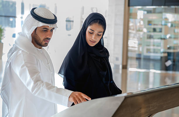 istock Arab Business Couple Using Interactive Directory in Modern Public Building Interior 2253106819
