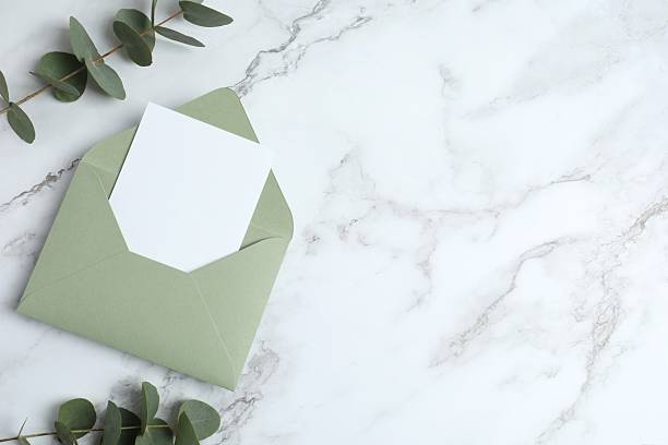 istock Romantic flat lay with paper envelope, blank card, eucalyptus branches on marble. Ideal for wedding invitations, event announcements, or feminine branding 2253107521
