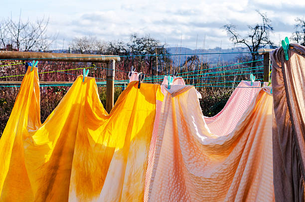 Brightly colored laundry drying on a clothesline in the sunshine with a hilly landscape background
