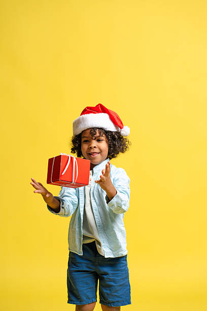istock Boy celebrating holidays, catching red Christmas gift present with joyful expression 2253108887