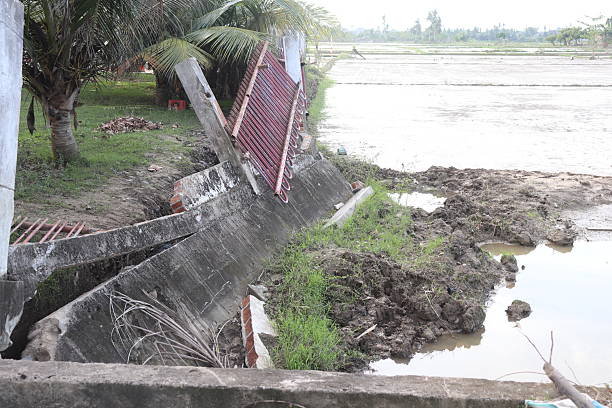 istock Collapsed Concrete Wall Aftermath Beside a Flooded Rice Paddy 2253109777