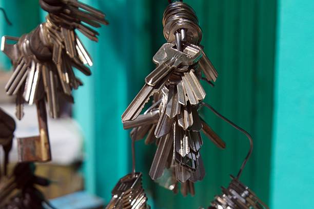 Metal Key Bundles Hanging on Wire Against Turquoise Wall