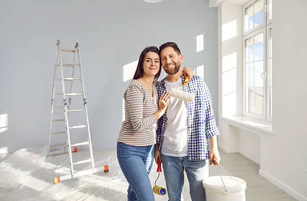 istock Happy young couple with paint rollers renovating their house 2253113186