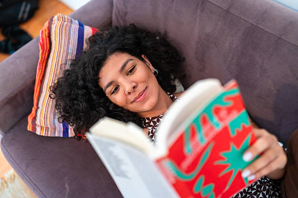 istock Woman reading book at home 2253113546