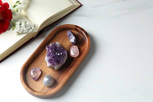istock Different beautiful gemstones, book and flowers on white marble table, flat lay. Space for text 2253114672