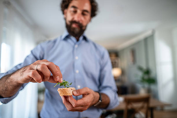 Man preparing healthy appetizer with arugula and bread