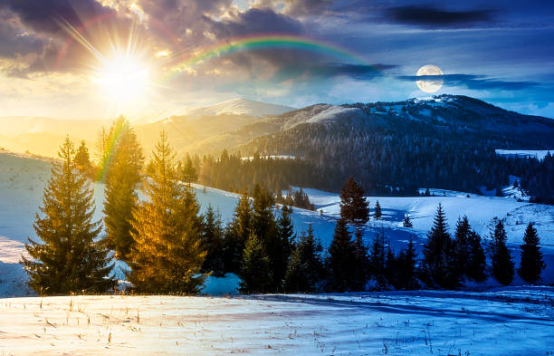 istock fir trees on snowy hillsides. day and night time change concept 2253116809