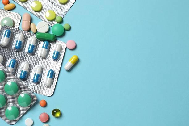 istock Pills in blister packs on blue background, close up 2253117567
